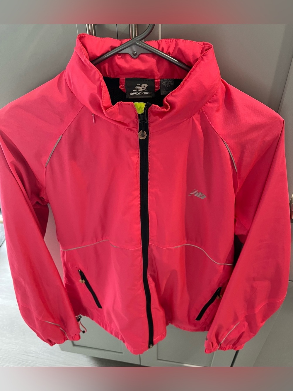 New Balance women’s hot pink rain coat with silver, black & neon green accents